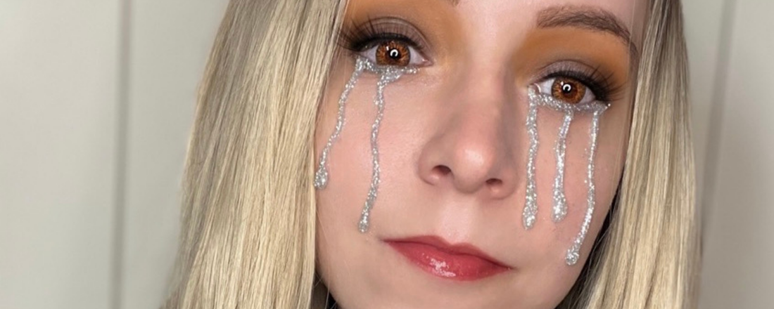 A lady with silver shimmery glitter tears dripping down her face for a halloween makeup look