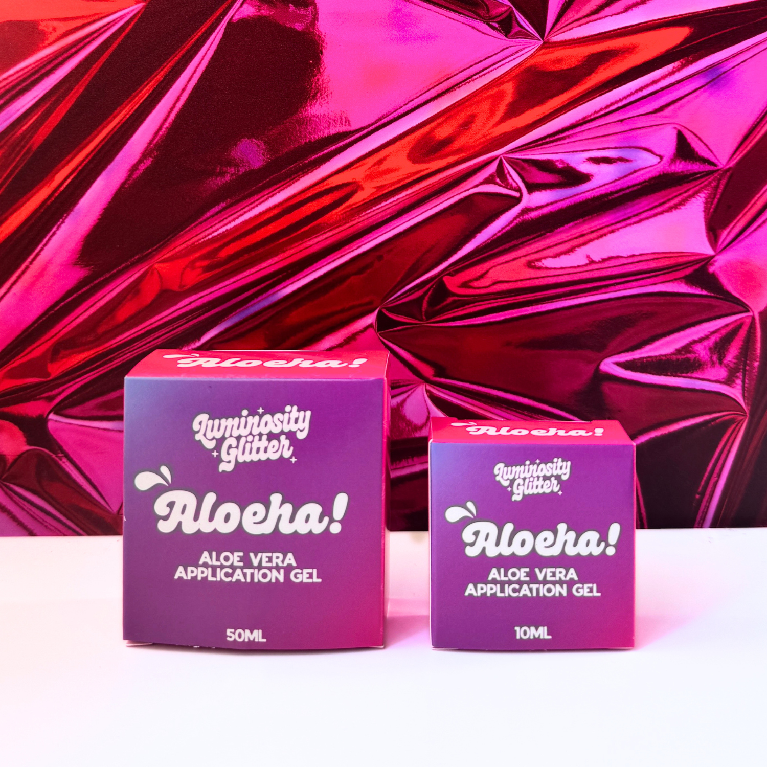 Two boxes of Aloeha Aloe Vera Application Gel on a reflective pink surface