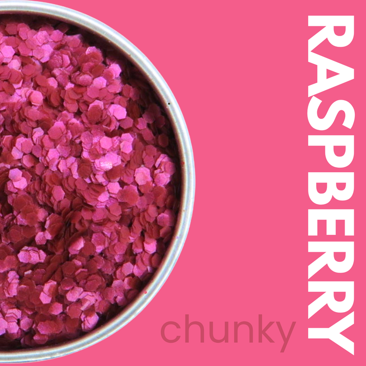 Container of raspberry-colored chunky glitter on a pink background with &