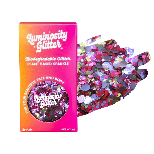Luminosity Glitter packaging with biodegradable and plant-based sparkle, next to a handful of glitter on a white background.