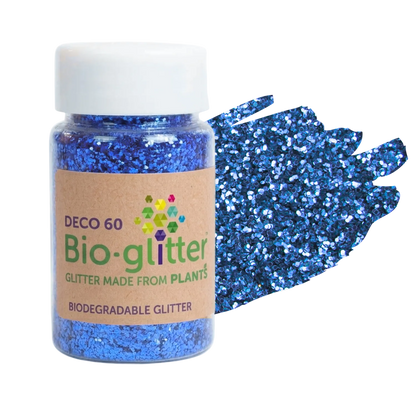 A bottle of blue craft Bio-glitter with a white cap and a kraft paper label, shown next to a textured swatch of the blue glitter on a white background.
