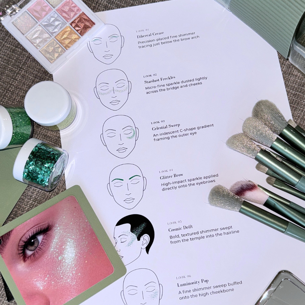 A makeup lookbook page showing step-by-step face illustrations and text for eyeshadow looks, styled with makeup brushes, glitter jars, an eye shadow palette, and a close-up of an eye on a textured fabric background.