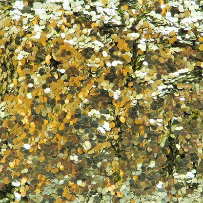 A close-up image of gold chunky eco glitter, showing various sizes of reflective gold particles.