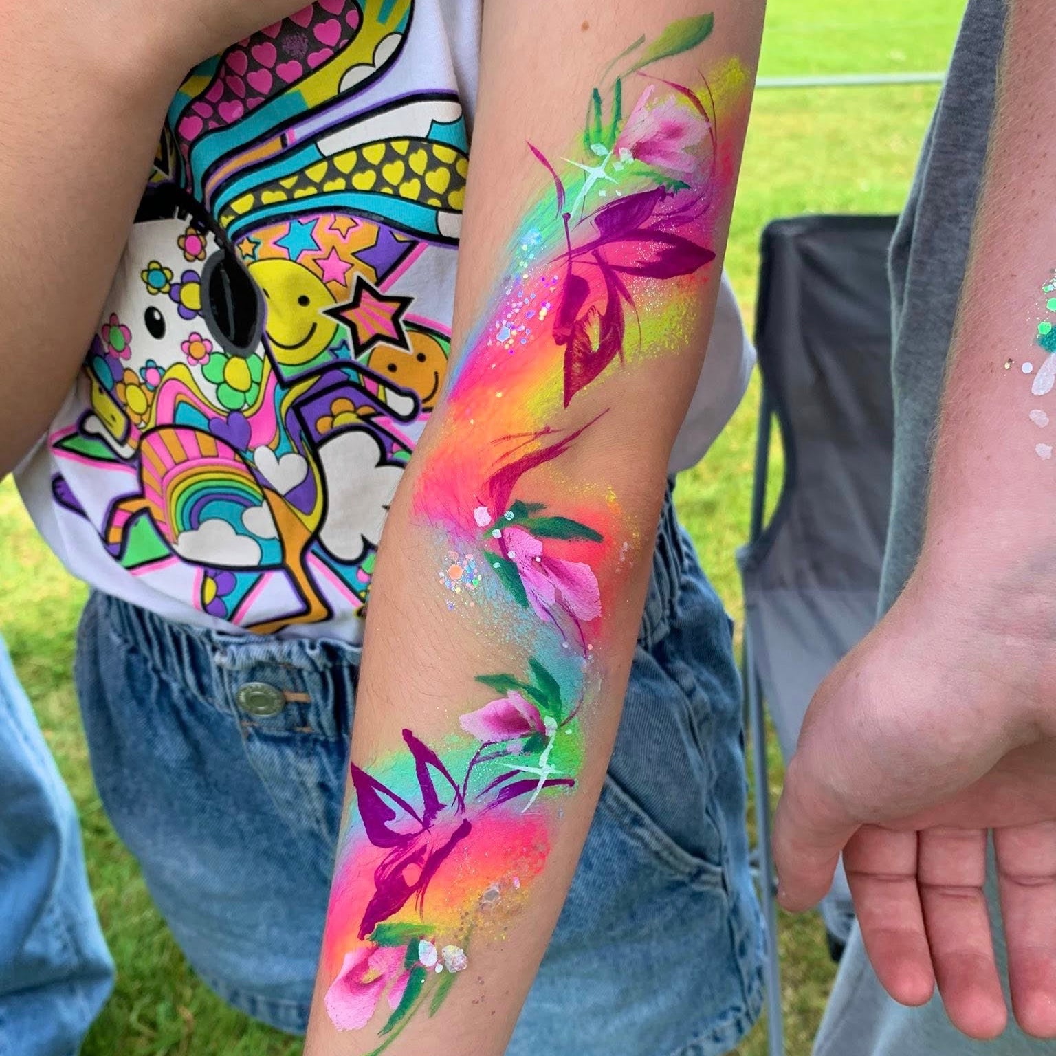 A bold neon body paint design on an arm