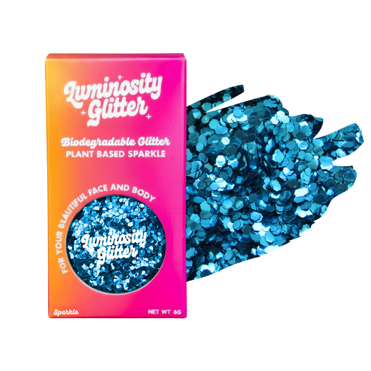 A pot of blue chunky biodegradable glitter in a bright pink and orange ombre box